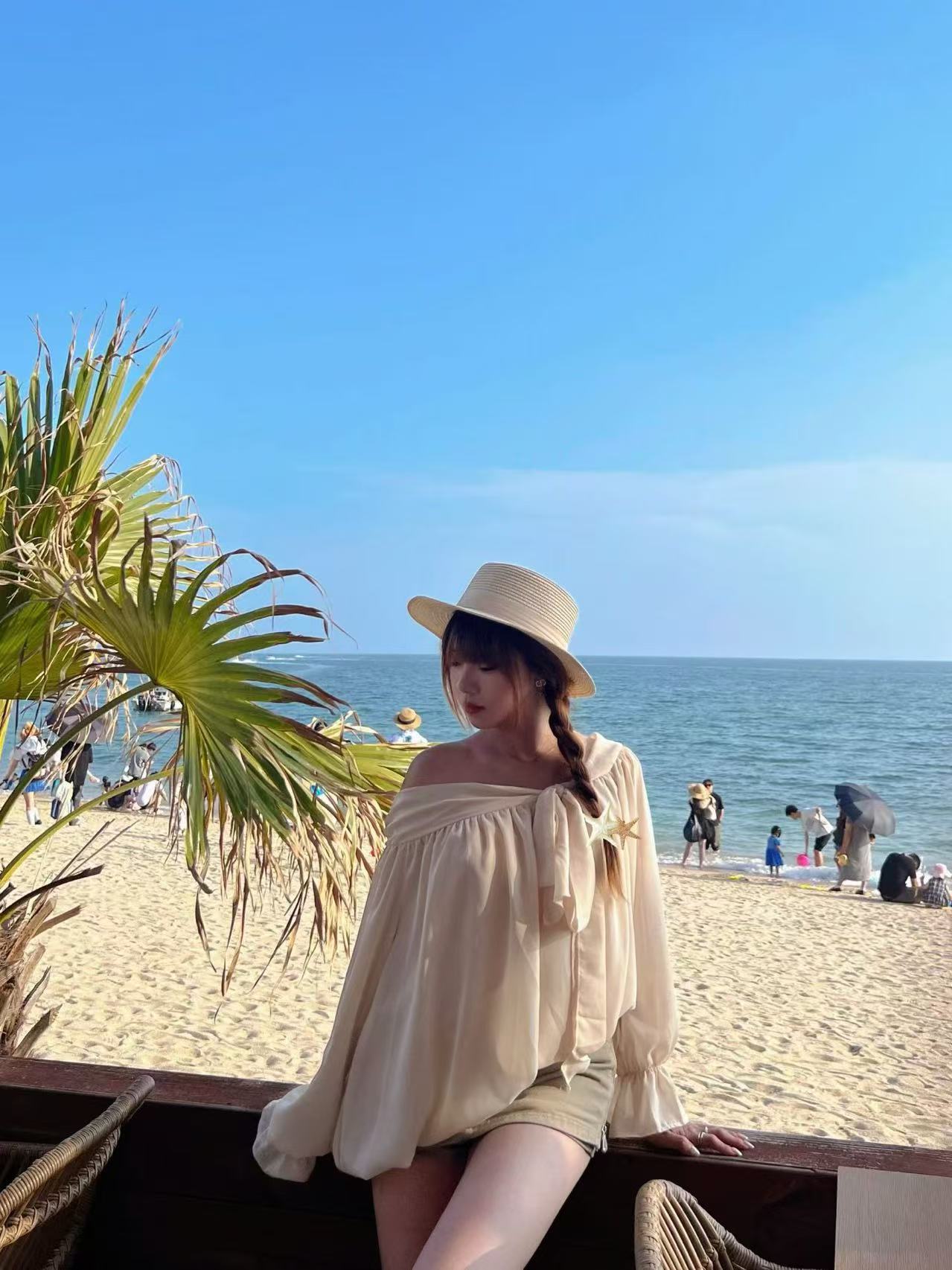 第一次旅游时在海边戴着草帽的照片