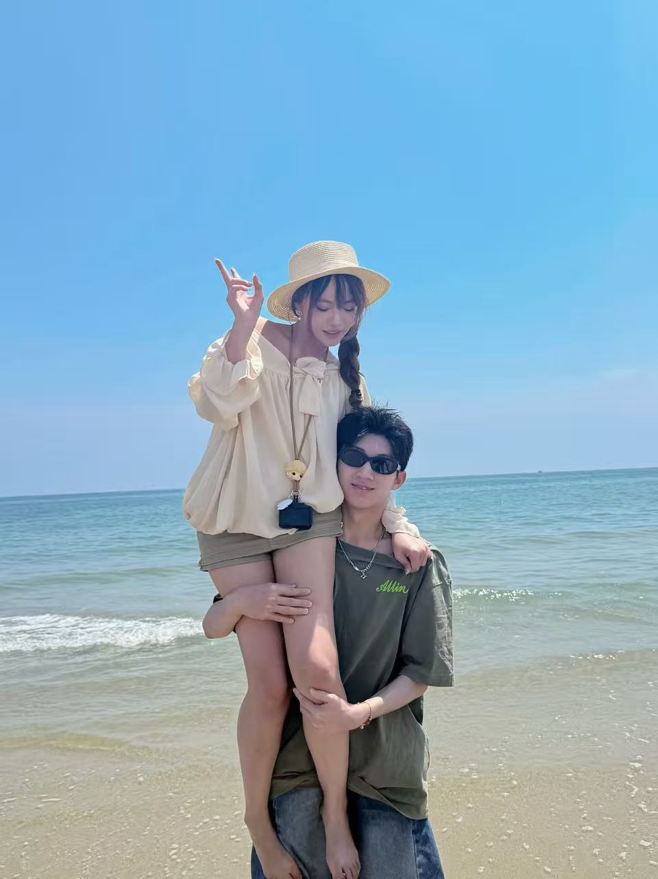 第一次旅游时在海边肩扛小 o 宝的合照